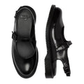The Dr. Martens Madaline Black Smooth Women's Slingback Mary Jane Shoes feature shiny black leather, buckle straps, thick soles, rounded toes, and the iconic Dr. Martens logo on the insole, shown from top and side views.