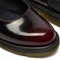 Close-up of Dr Martens Madaline Cherry Red Arcadia Women's Slingback Mary Jane Shoes with polished smooth leather, rounded toes, black cushioned insoles, contrasting stitching, and thick black soles with yellow-brown Goodyear welted edges.