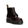 The Dr Martens Sinclair Cherry Red Arcadia Leather Platform Boot features high-shine leather, a thick sole, zipper front, maroon stitching, metal eyelets, and the signature yellow pull tab at the back.