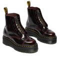 The Dr Martens Sinclair Cherry Red Arcadia Leather Platform Boot features high-shine burgundy leather, chunky black soles, yellow stitching, front zippers, black laces, and signature yellow pull tabs at the back., 51252, 190665278637, 190665278644, 190665278668, 51256