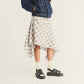 A person wearing a plaid skirt and black Dr Martens Wrenlie Flower Open Toe Black Milled Nappa Quad Sandal fisherman sandals with floral-shaped cutouts and ankle straps.