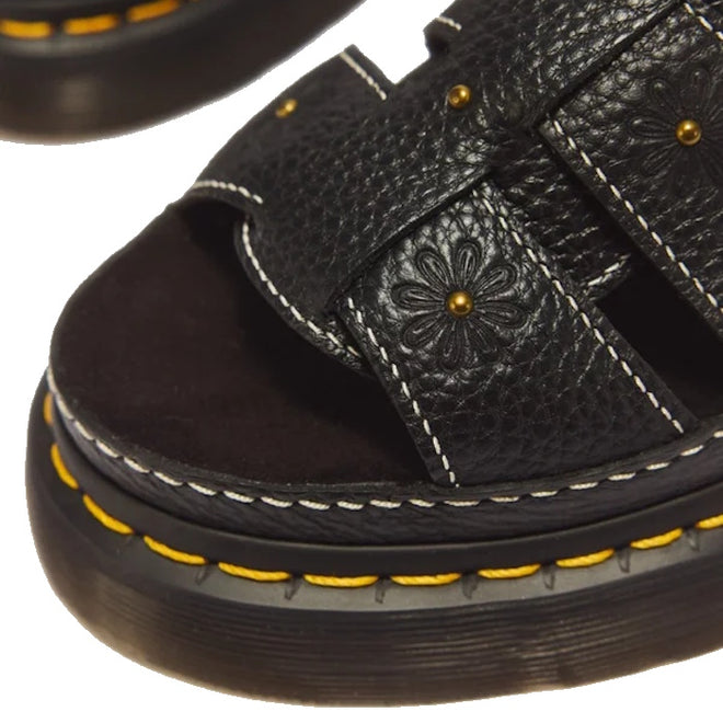 Dr Martens Wrenlie Flower Open Toe Black Milled Nappa Quad Sandal in black milled nappa leather with a textured strap featuring embossed flower motifs, brass studs, white contrast stitching, and yellow Goodyear welt stitching.