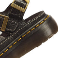 Close-up of a Dr Martens Wrenlie Flower Open Toe Black Milled Nappa Quad Sandal, a black leather fisherman sandal featuring yellow welt stitching and gold-toned buckles.