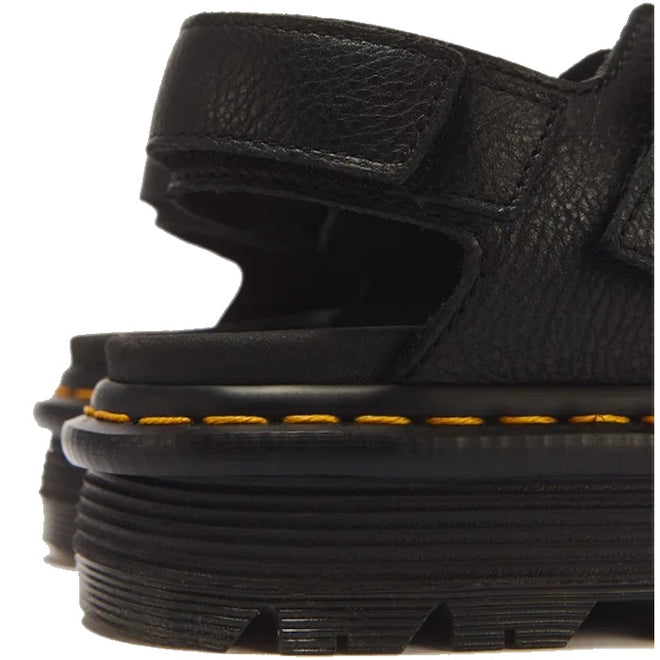Close-up of the heel area of a Dr Martens Zebzag Black Pisa Leather 3 Strap Sandal, featuring black Pisa leather, yellow stitching along the air-cushioned sole, and a thick, grooved rubber platform.
