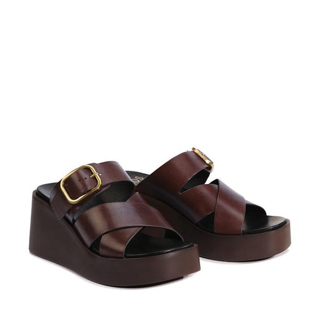 The EOS Aris Womens Chestnut Brown Leather Wedge Slide features premium calf leather, crisscross straps, gold buckles, and thick dark brown platform soles for stylish comfort and lasting durability., 48005, 9321191293646, 9321191293653, 9321191293660, 9321191293677, 9321191293684, 9321191293691