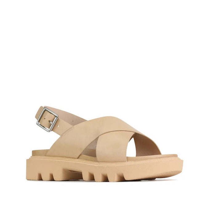 The EOS Womens Flighty Nude Chunky Look Leather Sandal features thick crisscross straps, a chunky grooved sole, an adjustable back ankle strap, and premium leather for a modern minimalist style.