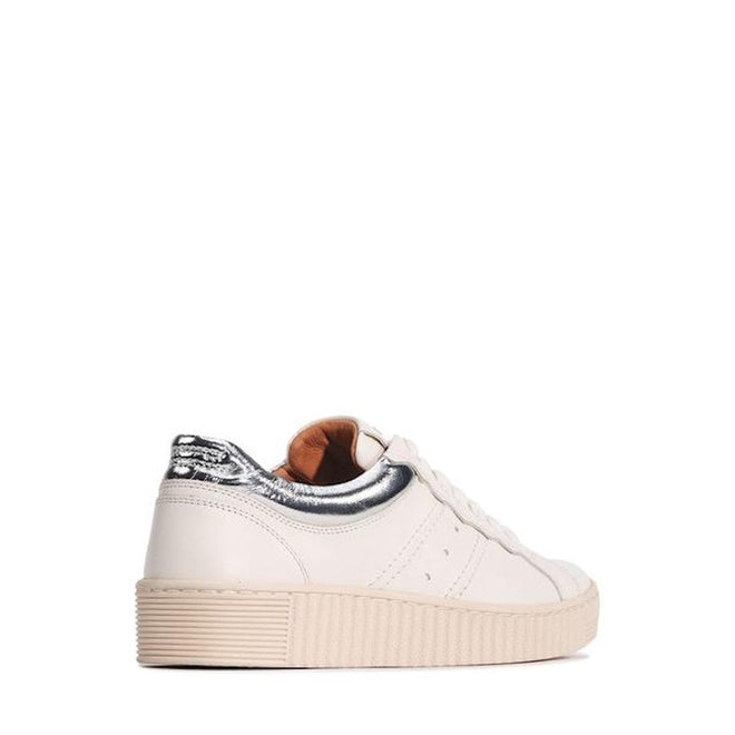The EOS Jolie Bone Beige Women's Leather Trainer features white leather, a cream sole, metallic silver heel patch, and side zip. Shown from the rear side on a white background, these sneakers blend comfort and style for everyday wear., 47242, 9321191308203, 9321191308210, 9321191308227, 9321191308234, 9321191308241, 47248