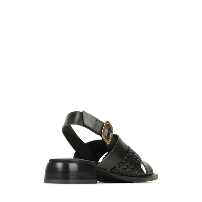 The EOS Laticia Black Leather Sandal features a mini block heel, woven strap detail, open toe, and an ankle strap with a gold buckle. Displayed against a white background., 41524, 9321191222943, 9321191222950, 9321191222967, 9321191222974, 9321191222981