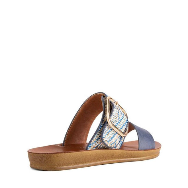 The Los Cabos Doti Navy Multi Light Flexible Sandal is a women's slip-on with a tan sole, blue strap, plus a textured blue-and-white strap with a large gold buckle. Designed for comfort and gentle arch support, it's pictured angled to show the back and side., 9321191299723, 9321191299730, 9321191299747, 9321191299754, 9321191299761, 9321191299778, 46912