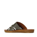 A side view of the Los Cabos Womens Bride Khaki Flat Slide Sandal, featuring green crisscross leather straps and a brown textured flat sole—perfect for resort wear—is set against a white background.