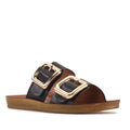 The Los Cabos Womens Dina Black Light Flexible Two Strap Slide Sandal features a black design with two wide straps, each accented by a large gold buckle, and a flat brown sole, all crafted with an anatomical footbed for enhanced comfort.