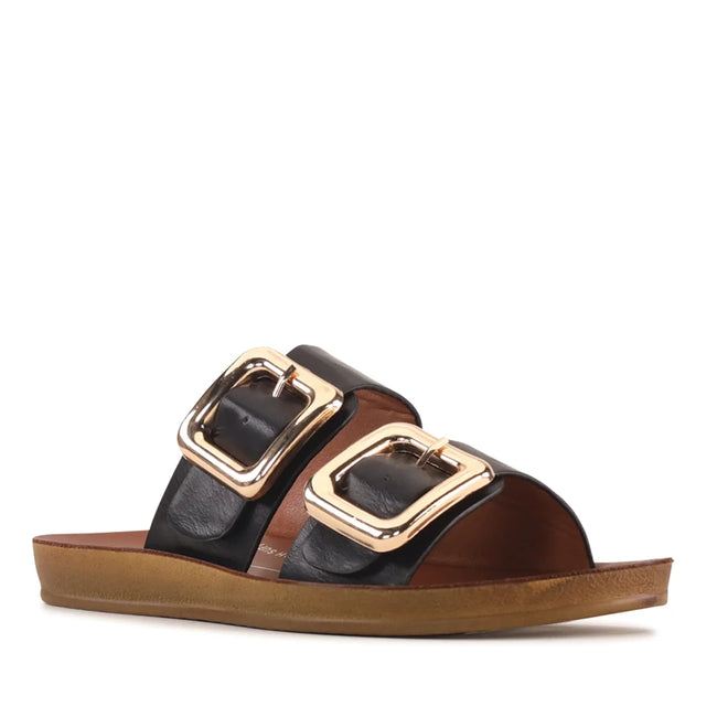 The Los Cabos Womens Dina Black Light Flexible Two Strap Slide Sandal features a black design with two wide straps, each accented by a large gold buckle, and a flat brown sole, all crafted with an anatomical footbed for enhanced comfort.