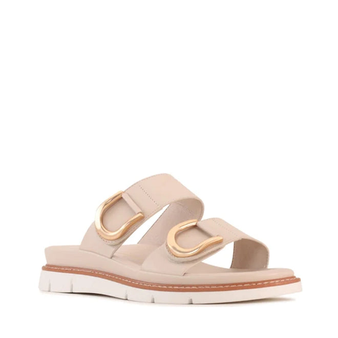 The Los Cabos San Women’s Slide Double Strap Sandal in Bone features two wide straps with gold buckle accents, a cushioned footbed, tan trim, and a thick white grooved sole—making it the perfect minimalist slide for comfortable summer wear., 9321190067897, 9321190067903, 9321190067910, 9321190067927, 9321190067934, 9321190067941, 53741