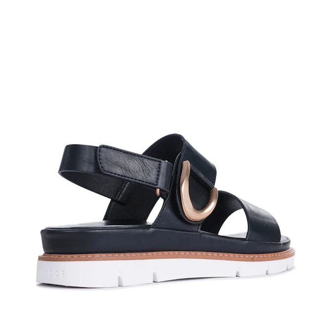 The Los Cabos Sana Black Sandal With Back Strap features a white sole, brown trim, thick black straps, an adjustable slingback strap, and a large metallic gold decorative buckle on the side—making it the perfect comfortable summer sandal., 9321191314006, 9321191314013, 9321191314020, 9321191314037, 9321191314044, 9321191314051, 53748