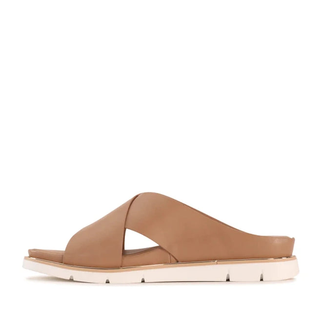 The Los Cabos Terigal Women’s Slide Cross Over Sandal in Taupe features wide, crisscross leather straps and a cream-colored flat sole with a cushioning footbed, displayed in a side profile against a white background., 9321190077964, 9321190077971, 9321190077988, 9321190077995, 9321190078008, 9321190078015