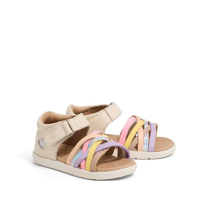The Pretty Brave 1st Walker Eden Rainbow Leather Open Toe Sandal for girls features pastel pink, yellow, and purple crisscross straps, beige soles, and adjustable ankle straps. The sandals are displayed on a white background.