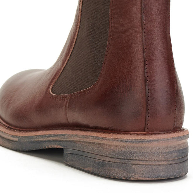 Close-up of the heel and side of the Rollie Womens Chelsea Rise Vintage Mocha Leather Boot, featuring brown premium leather, an elastic panel, detailed stitching, and a slightly worn Vibram outsole., 9339554341682, 9339554341699, 9339554341705, 9339554341712, 9339554341729
