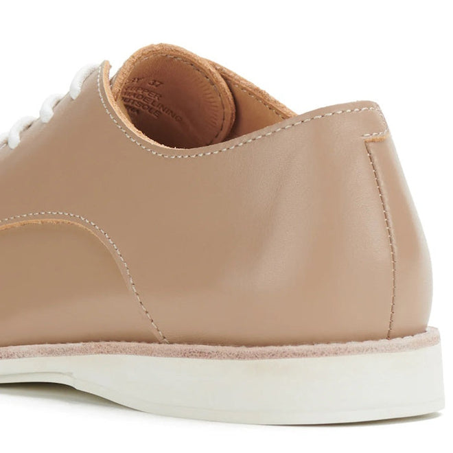 A close-up of the Rollie Womens Derby Super Soft Latte Leather Shoe features a premium beige leather heel and back, white stitching, white laces, and a white rubber sole for superior comfort., 9781760763848, 9781760763855, 9781760763862, 9781760763879, 9781760763886