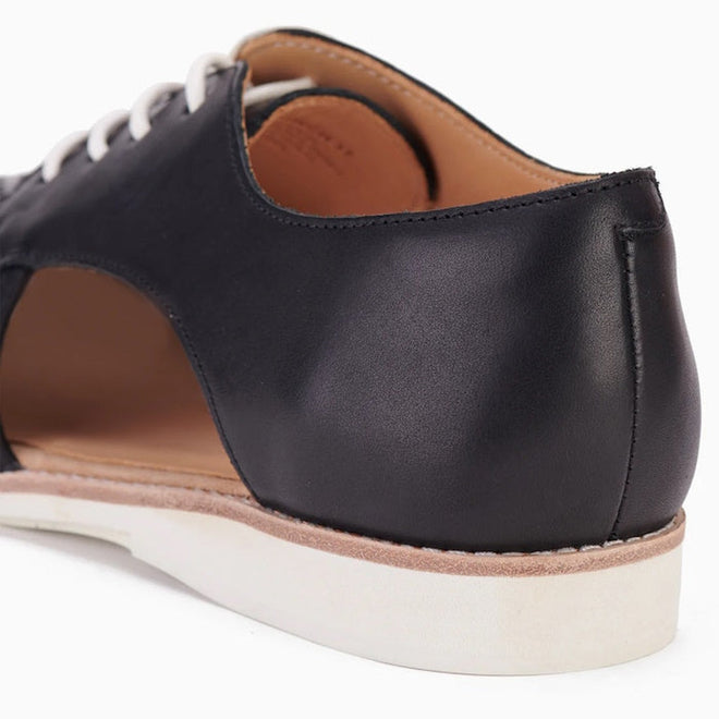 Close-up of the Rollie Womens Sidecut Punch Black Leather Shoe, showing black leather with white laces, tan interior, white rubber sole, cut-out heel design for breathability, and cushy EVA midsoles for all-day comfort., 9339554249179, 9339554249186, 9339554249193, 9339554249209, 9339554249216, 9339554249223, 9339554249230