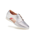 The Rollie Womens Sidecut Punch Silver Metallic Leather Shoe features metallic silver leather, white laces, perforated detailing for breathability, a white sole, and a pink inner heel accent, shown against a white background.