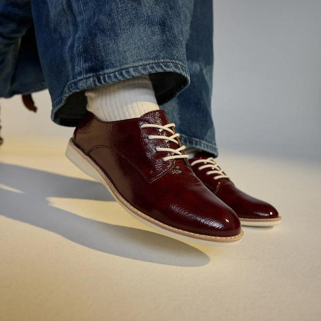 Burgundy Rollie Derby brouge leather shoes with white laces on a models feet worn with blue jeans and white ankle socks on a neutral background.,
9781760788742,
9781760788759,
9781760788766,
9781760788773,
9781760788780,
9781760788797,
9781760788803,