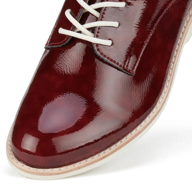 Close-up of toe of the left foot of a Rollie Derby Super soft Wine Crinkle Patent glossy burgundy shoe with white laces on a white background.,
9781760788742,
9781760788759,
9781760788766,
9781760788773,
9781760788780,
9781760788797,
9781760788803,