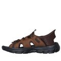 The Skechers Mens Revolted SS Merrick Slip In Sandals in Dark Brown feature cut-out sides, a closed heel, adjustable straps, and a comfort footbed with a thick textured sole—perfect for outdoors and inspired by Skechers Hands Free Slip-ins., 47447, 47448, 197627623641, 197627623658, 197627623665, 47452, 47453