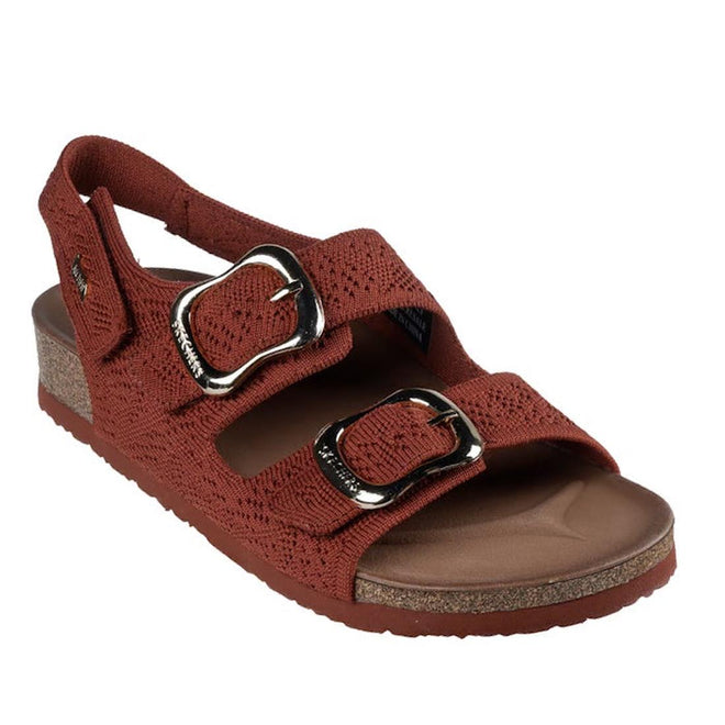 The Skechers Womens Arch Fit Granola Special Summer Cinnamon Rust Sandal is a brown vegan slide with two large silver buckles, adjustable knit straps, slingback heel, open toe, low textured platform sole, and podiatrist-certified arch support.