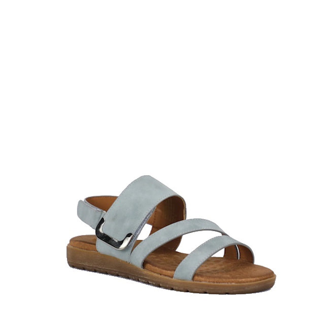 The Soultbush Flinders Denim Women’s Sandal with Back Strap is a light blue sandal featuring three straps and an open toe, complemented by a brown flat sole and a cushioned footbed for all-day comfort. An adjustable Velcro back strap ensures a secure fit. The sandal is displayed against a plain white background.