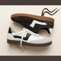 Two Gelato Staton Swan Off White and Cafe Leather Lace Women's Sneakers are displayed side by side, featuring gum soles, retro design, and "1972" in gold on the heel—one in off-white with black accents, the other in brown with white details., 52483, 52484, 52485, 52486, 52487, 52488