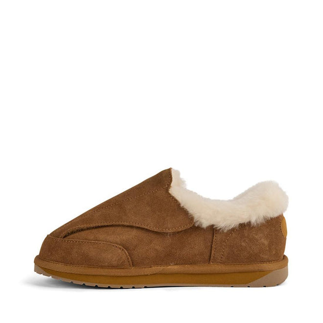 The EMU FlexiCare Wide Opening Sheepskin Slippers in Chestnut feature a brown suede upper, plush white shearling lining, and a rubber sole, shown in side profile against a plain white background., 9330071990957, 9330071990964, 9330071990971, 9330071990988, 9330071990995, 9330071991008, 52510, 52511, 52512