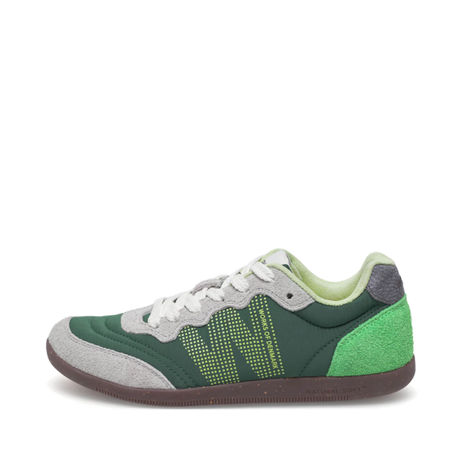 The Woden Nanna Apple Green Multi Lace Up Sneaker features a green and gray ultralight design with brown sole, white laces, lime green details, a dotted N logo, and suede accents—shown on a white background for a sleek, travel-friendly look.