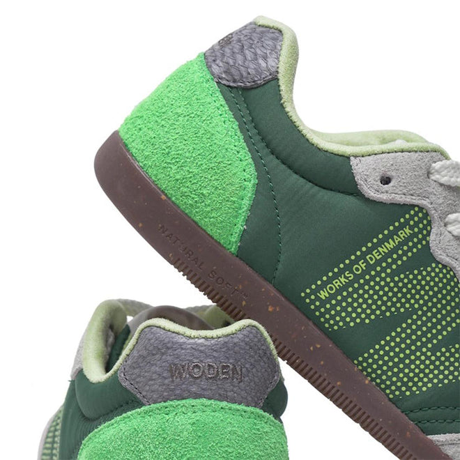 Close-up of Woden Nanna Apple Green Multi Lace Up Sneakers, featuring green tones with gray and light green accents, textured materials, WORKS OF DENMARK text on the side, WODEN on the heel, and a brown NATURAL SOFT sole., 50250, 5713326697834, 5713326697841, 5713326697858, 50253
