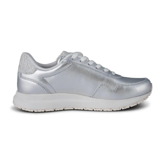The Woden Womens Sneaker Nora Natural Soft Metallic Silver features a silver finish, white laces, and a recycled rubber sole, shown from the side on a plain white background., 42438, 5713326588613, 5713326588620, 5713326588637, 5713326588644, 42443