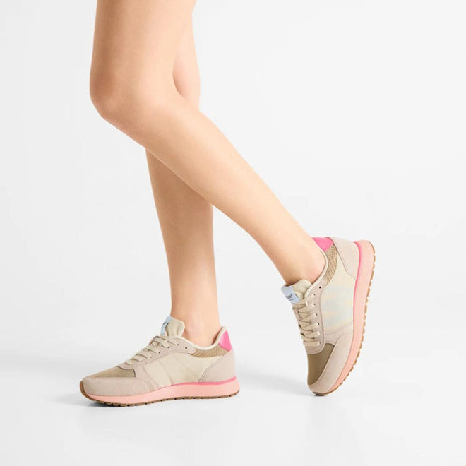 Someone stands on tiptoe against a plain white background, showcasing the side and back of the Woden Ronja Ivory Blush Lace Up Sneaker in beige and pink leather with white soles., 50265, 5713326700633, 5713326700640, 5713326700657, 5713326700664, 5713326700671