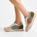 A person wearing Woden Ronja Icon Light Algae Multi Lace Up Sneakers, featuring certified suede, mesh details, and the WODEN Air Flow System in green, pink, and beige, stands on tiptoe against a plain white background., 50275, 5713326699838, 5713326699845, 5713326699852, 50279