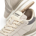A close-up of Woden Ronja Plateau Delpin Lace Up Sneakers in beige and gray, highlighting laces, side panels, fish leather heel accents, and a “WODEN - HOUSE OF DENMARK” brand label on the tongue., 5713326692365, 5713326692372, 5713326692389, 5713326692396, 5713326692402