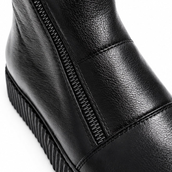 Close-up of the Alfie & Evie Womens Dynasty Black Leather Ankle Boot, showcasing its visible zipper, detailed stitching, and a textured creeper sole for a bold look., 50918, 50919, 50920, 50921, 50922, 50923, 50924