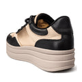 The Alfie & Evie Isaac Black Leather Women's Platform Sneaker features a thick beige platform sole, beige upper, and black accents on the heel, toe, and laces. Shown from the back on a white background.