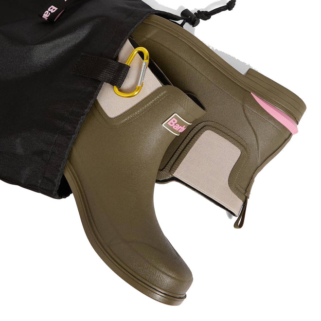 Barbour Abbeyfield Packable Ankle Wellingtons Olive with beige elastic sides, pink accents, yellow pull tab, and textured finish are shown partially pulled from a black drawstring bag. These lightweight wellies are easy to pack and stylish., 51830, 51831, 5063669171264, 5063669171271, 5063669171288, 51835, 51836
