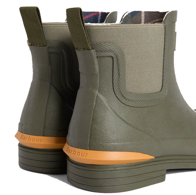 A close-up of the back of two Barbour Abbeyfield Packable Ankle Wellingtons Olive showcases their olive green color, orange soles, pull tabs, fabric sides, and Barbour branding above the heels. These lightweight wellingtons are perfect for on-the-go adventures, blending practicality with timeless style., 51830, 51831, 5063669380604, 5063669380611, 5063669380628, 51835, 51836