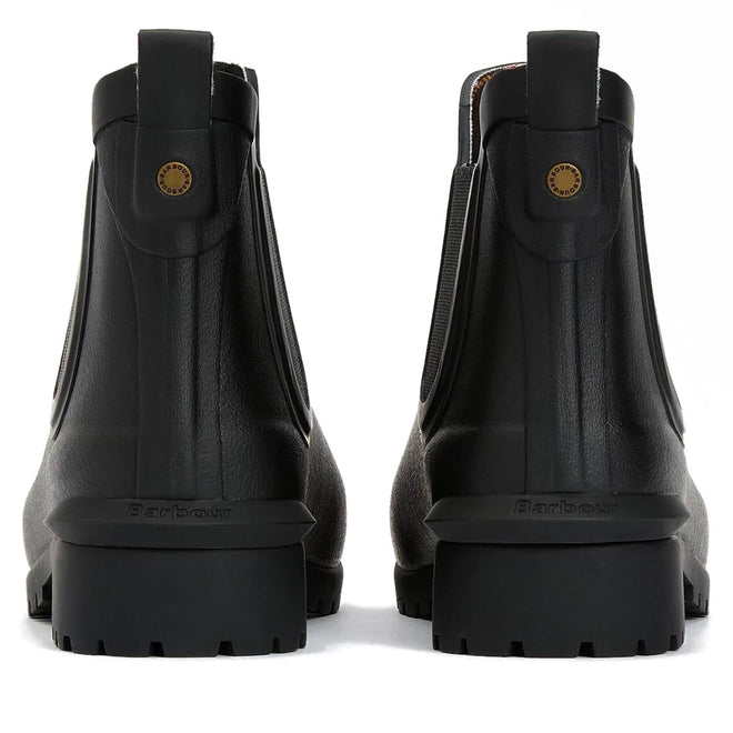 Rear view of a pair of Barbour Wilton Black Chelsea Wellingtons Women's Rainboots featuring chunky soles, pull tabs, tartan lining peeking out, and a small round gold detail on the back., 190375411423, 190375411546, 190375411614, 190375411768, 190375411850, 190375412024