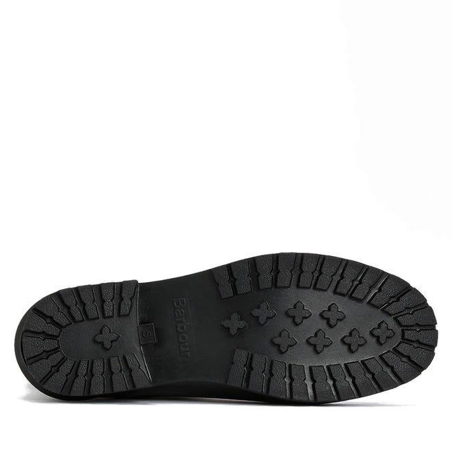 The black rubber sole of the Barbour Wilton Black Chelsea Wellingtons Womens Rainboot is shown from below, revealing a tread with rectangular grooves and cross-shaped grips., 190375411423, 190375411546, 190375411614, 190375411768, 190375411850, 190375412024