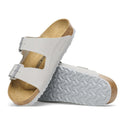 a pair of Birkenstock Arizona Birko Flor Stone Coin Grey Regular Width with double straps, one over the foot and one over the toes with buckle adjustment. Staps are linked at the sides of the foot. Synthetic straps and a suede leather footbed,