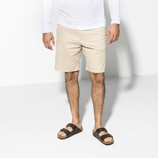 A pair of dark brown natural leather Birkenstock Arizona slide son a mans feet. He is wearing beige shorts and a white long sleeve t-shirt.,
4013871069898,36750,4013871008354,4013871009184,4013871021544,4013871037750,4013871041603,4013871063766,4013871063865,4013871066453,4013871076551,4013871077572, 
