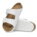 a pair of Birkenstock Arizona Smooth (Pebbled) Leather White Narrow Width with double straps, one over the foot and one over the toes with buckle adjustment. Staps are linked at the sides of the foot. Leather thick straps and a suede leather footbed,