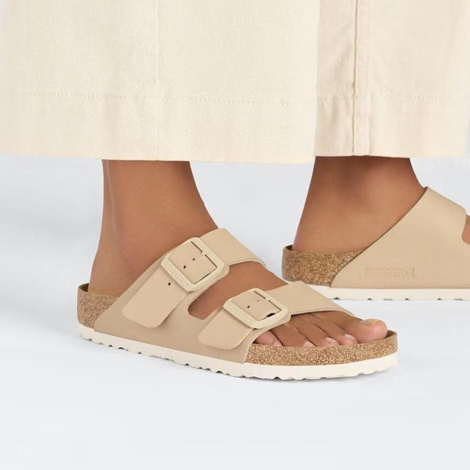 Beige sandals worn with a light-colored skirt on a white background,
4066648430384,
4066648430421,
4066648430469,