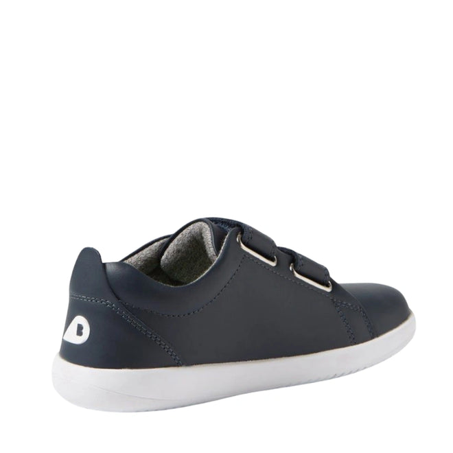 The Bobux KP Kids Plus Grass Court 2 II Leather Sneaker in Navy features a dark blue leather upper, two adjustable Velcro straps, a white sole, and a small white heel logo, shown angled from the back left., 9420074831255, 9420074831262, 9420074831279, 9420074831286, 9420074831293, 9420074831309, 9420074831316