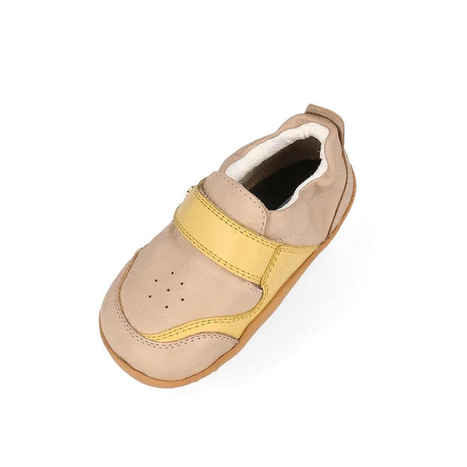 The Bobux XP Explorer Ripple First Walker Sneaker Beige 502502 features a beige and yellow design, velcro strap, perforated toe, and flexible sole, displayed at an angle on a white background., 9420075784345, 9420075786035, 9420075785083, 9420075786318