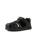 The Bobux Kid+ Roam Black School Leather Sandal Closed Toe Junior features a velcro strap, multiple side cutouts, and a flat sole—ideal as black leather school sandals for kids. Photographed on a white background.